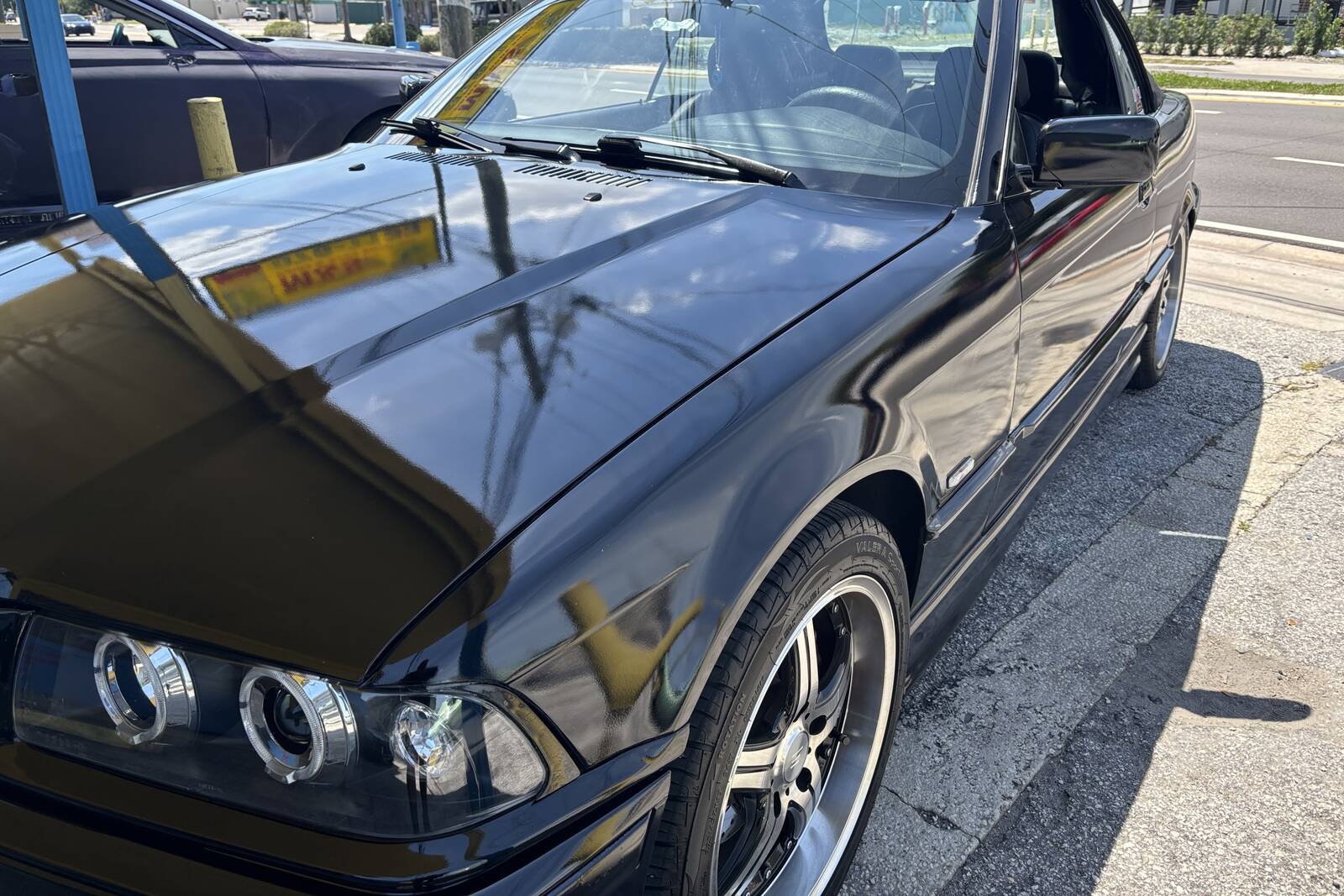 A black BMW convertible with a fresh, glossy repaint.