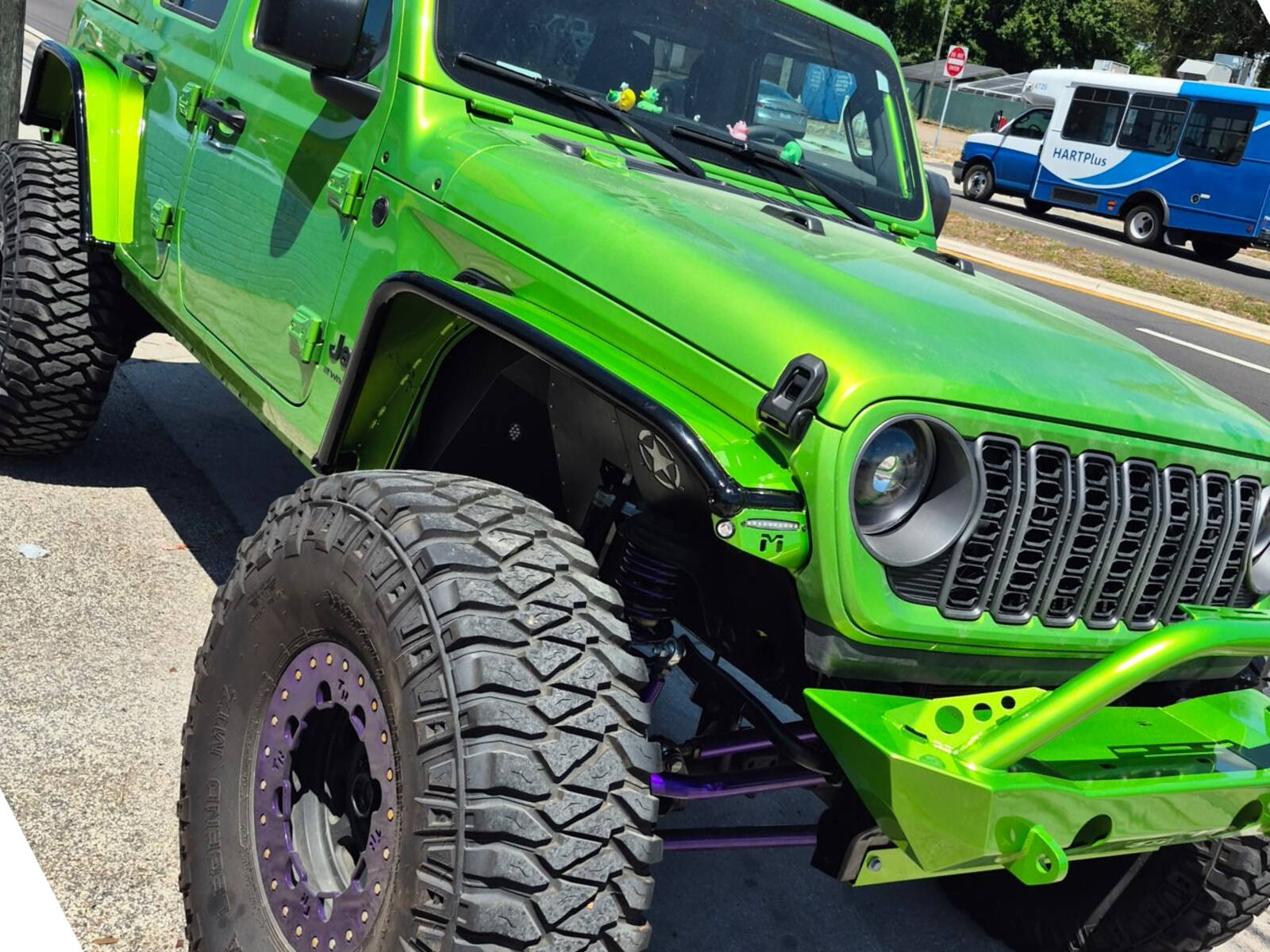 A bright green Jeep with custom paint and large off-road tires.