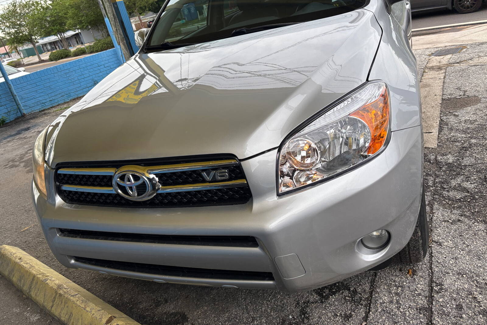 Before and after of a silver SUV: front-end collision damage repaired at the shop.